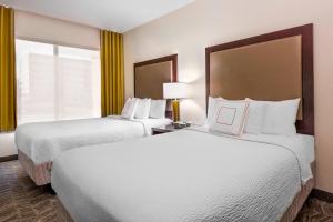卡梅尔印第安纳波利斯卡梅尔春季山丘套房酒店的酒店客房设有两张床和窗户。