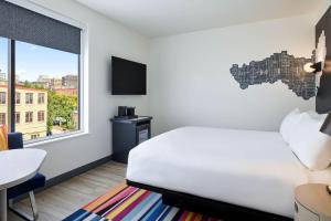 波特兰Aloft Portland Downtown Waterfront ME的卧室配有白色的床和窗户。