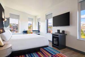 波特兰Aloft Portland Downtown Waterfront ME的配有一张床和一台平面电视的酒店客房