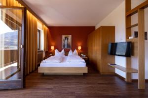梅拉诺Residence Pollingerhof的配有一张床和一台平面电视的酒店客房