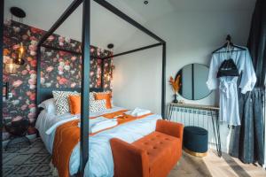 滕比Priory Bay Escapes - Visum的一间卧室配有一张带橙色椅子的天蓬床