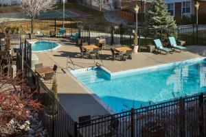 Cottonwood Heights盐湖城杨木住宅旅馆的围栏旁带桌椅的游泳池