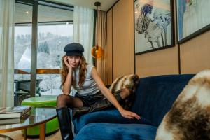 苏黎世FIVE Zurich - Luxury City Resort的坐在房间里沙发上的女孩