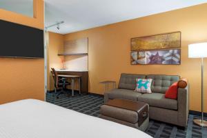 萨凡纳萨凡纳城中区广场套房酒店的酒店客房配有一张床、一张沙发和一张书桌。