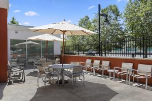 萨克拉门托SpringHill Suites by Marriott Sacramento Natomas的一个带桌椅和遮阳伞的庭院