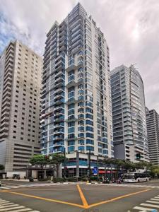 马尼拉The Pearl Interior Designed 1 BR Unit Burgos Circle BGC的一条城市街道,有高大的建筑背景