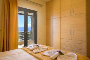 伊罗达Elounda Blue Waves Residence的一间卧室配有带毛巾的床和窗户。