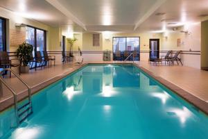 路易斯威尔路易斯维尔市中心春季山丘套房酒店的大楼内一个带桌椅的游泳池