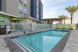 普拉森SpringHill Suites by Marriott Anaheim Placentia Fullerton的一座带椅子的游泳池以及一座建筑