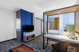 塔尔萨塔尔萨塔尔萨丘陵万豪春季山丘套房酒店的酒店客房配有书桌、床和电视。