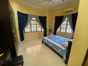大山脚Idaman homestay的一间卧室设有一张床和两个窗户。