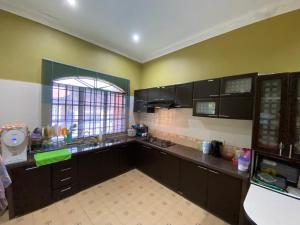 大山脚Idaman homestay的一间设有黑色橱柜和窗户的大厨房