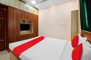 布巴内什瓦尔OYO Pratikshya A1 Residency的卧室配有带红色枕头的白色床