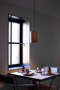FloreffeChambres de Gilberoux的一张桌子,上面有盘子和杯子,还有一个窗口