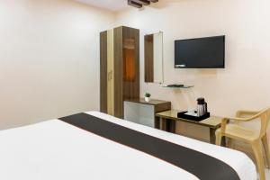 JalāripetaCapital O Mvp Check Inn的酒店客房设有一张床、一张书桌和一台电视机。