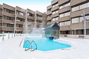 魁北克市三角洲魁北克万豪酒店的建筑物前雪地中的游泳池
