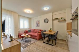 兹拉蒂博尔Koti apartman Zlatibor的客厅配有红色的沙发和桌子