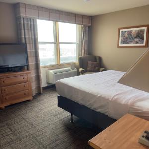 德卢斯Duluth Inn & Suites Near Spirit Mountain的酒店客房,配有床和电视