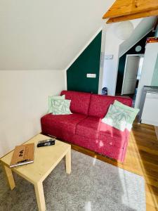 UrbarFerienwohnung „Klein aber fein“的客厅配有红色沙发和茶几