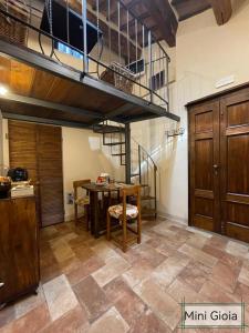 皮恩扎PienzaLettings "Casa Gioia"的一间带桌子和螺旋楼梯的厨房