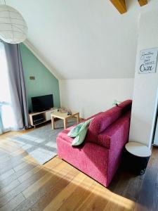 UrbarFerienwohnung „Klein aber fein“的客厅配有粉红色的沙发和桌子