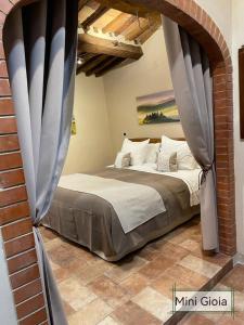 皮恩扎PienzaLettings "Casa Gioia"的卧室配有砖墙内的床铺