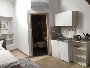 卢布尔雅那Aparthotel Cross Street 4的一间带白色橱柜的小厨房和一间浴室