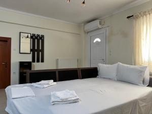 弗洛伊塔Archontia Apartment的卧室配有带毛巾的大型白色床