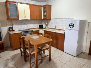 弗洛伊塔Archontia Apartment的厨房配有桌子和白色冰箱。