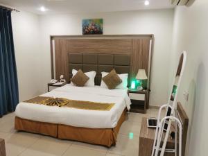 阿可贺巴فندق سمأ الرفاع 2的一间卧室配有一张大床和大床头板