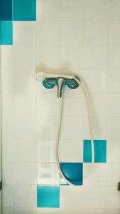 埃里塞拉70年代旅舍的浴室铺有蓝色和白色瓷砖,配有淋浴头。