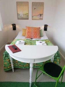 马斯塔尔Femmasteren Hotel & Hostel的客房设有一张带白色桌椅的床。