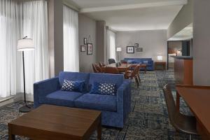 加蒂诺Four Points by Sheraton Hotel & Conference Centre Gatineau-Ottawa的客厅配有蓝色的沙发和桌子