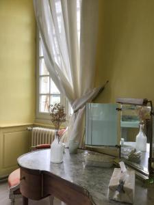 NouicChateau du Fraisse的客房设有带镜子的桌子和窗户