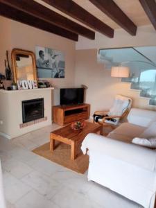 卡拉莫若尔Villa Amor的带沙发、桌子和电视的客厅