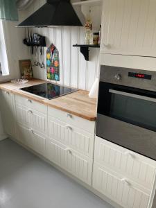 拉尔维克Verningen Apartment的厨房配有白色橱柜和炉灶。