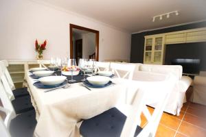 苏安塞斯Chalet junto a playa de Suances的一间设有白色桌子和白色椅子的用餐室