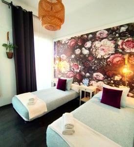 圣地亚哥－德孔波斯特拉Hostal Mafer的花卉墙面的客房内的两张床