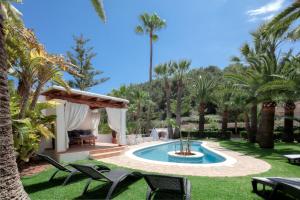伊维萨镇CAN TEO - Holiday Villa in Ibiza的一个带游泳池和棕榈树的后院