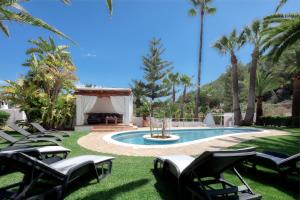 伊维萨镇CAN TEO - Holiday Villa in Ibiza的一个带草坪椅和凉亭的游泳池