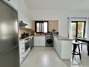 皮斯索里Zeus Holiday Home的白色的厨房配有水槽和洗碗机