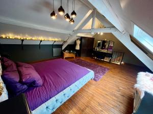 MélinLe Secret de Mélin的阁楼卧室配有一张大型紫色床