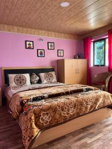 大吉岭Kheychun homestay的卧室配有一张带粉红色墙壁的大床