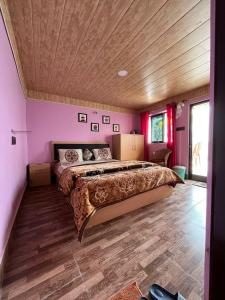 大吉岭Kheychun homestay的一间卧室设有一张大床和木制天花板
