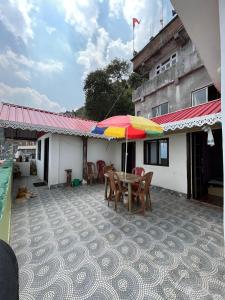 大吉岭Kheychun homestay的房屋内带桌子和遮阳伞的天井