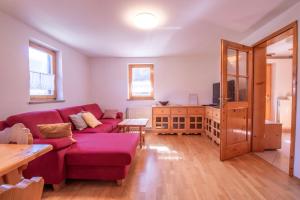 班斯卡比斯特里察River Valley View House的客厅配有红色的沙发和桌子