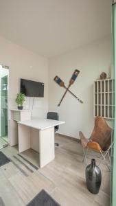 维纳德马Praia 58 Reñaca的办公室设有白色的书桌、电视和椅子