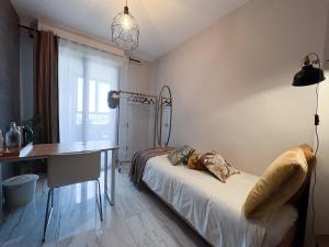米兰Holy-Day Rooms Milano的一间卧室配有一张床、一张桌子和一盏灯