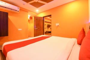 KhandagiriOYO Ssj Residency的一间卧室配有一张带橙色墙壁的大床