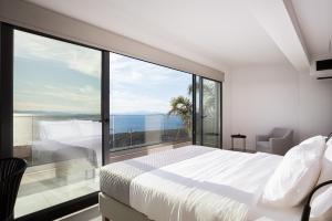 萨罗尼扎Saronida Hills的一间卧室设有一张床和一个大窗户